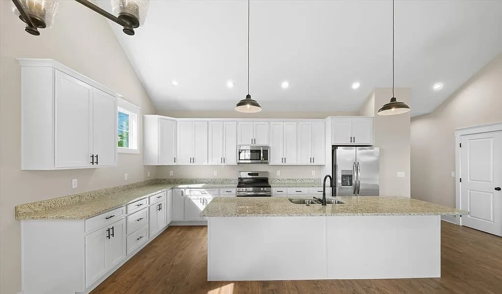 Kitchen wide view with stainless appliances and large island — S&T Construction