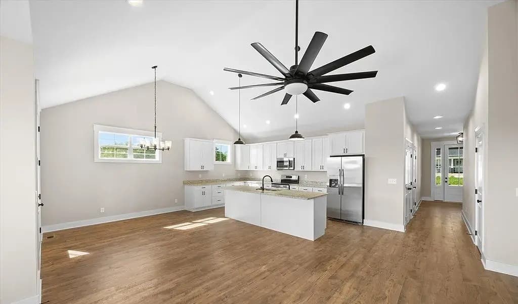 Open great room and kitchen with vaulted ceiling — The Kaley by S&T Construction