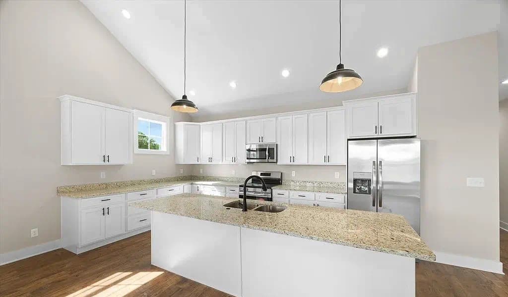 Kitchen showing full run of cabinetry with pendant lighting — The Kaley by S&T Construction